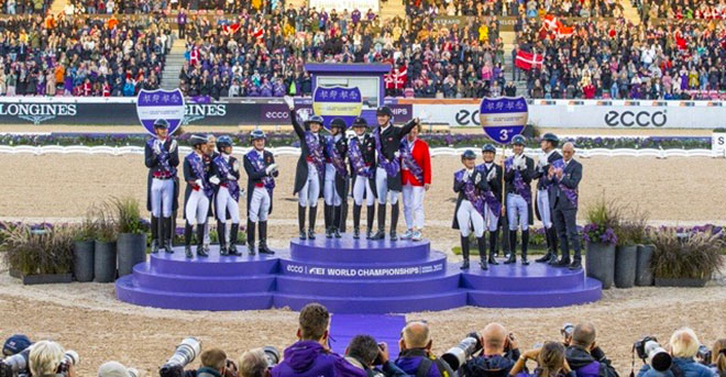 Sur le podium des championnats du monde de dressage : (de gauche à droite) les médaillés d'argent de Grande-Bretagne, les médaillés d'or du Danemark et les médaillés de bronze d'Allemagne (© FEI/Leanjo de Koster)
